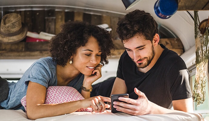 Muž a žena dívající se na mobilní telefon